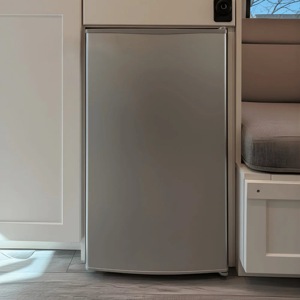 Compact stainless steel van refrigerator installed in a modern RV interior