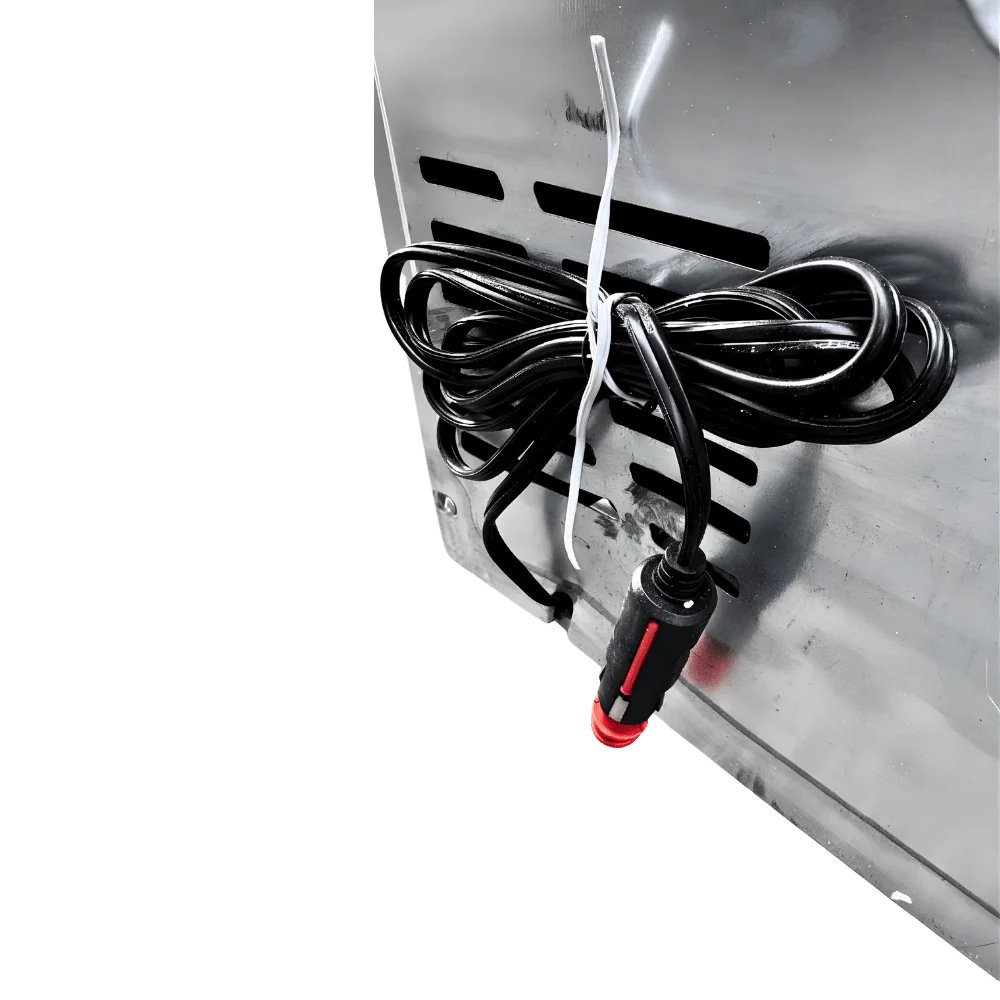 Close-up of coiled power cable with plug attached to metal van part