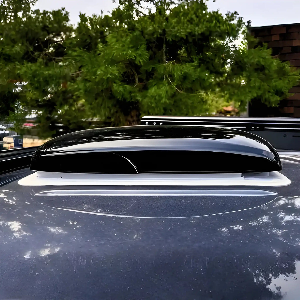 Cryonex RV roof ventilation fan installed on a van roof with its black exterior lid closed.