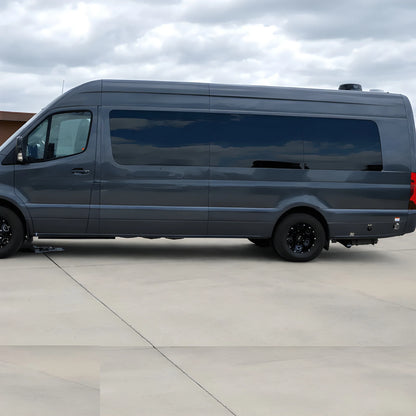 Driver-side view of a gray Mercedes Sprinter with tinted fixed windows along the front, middle and rear side panels.