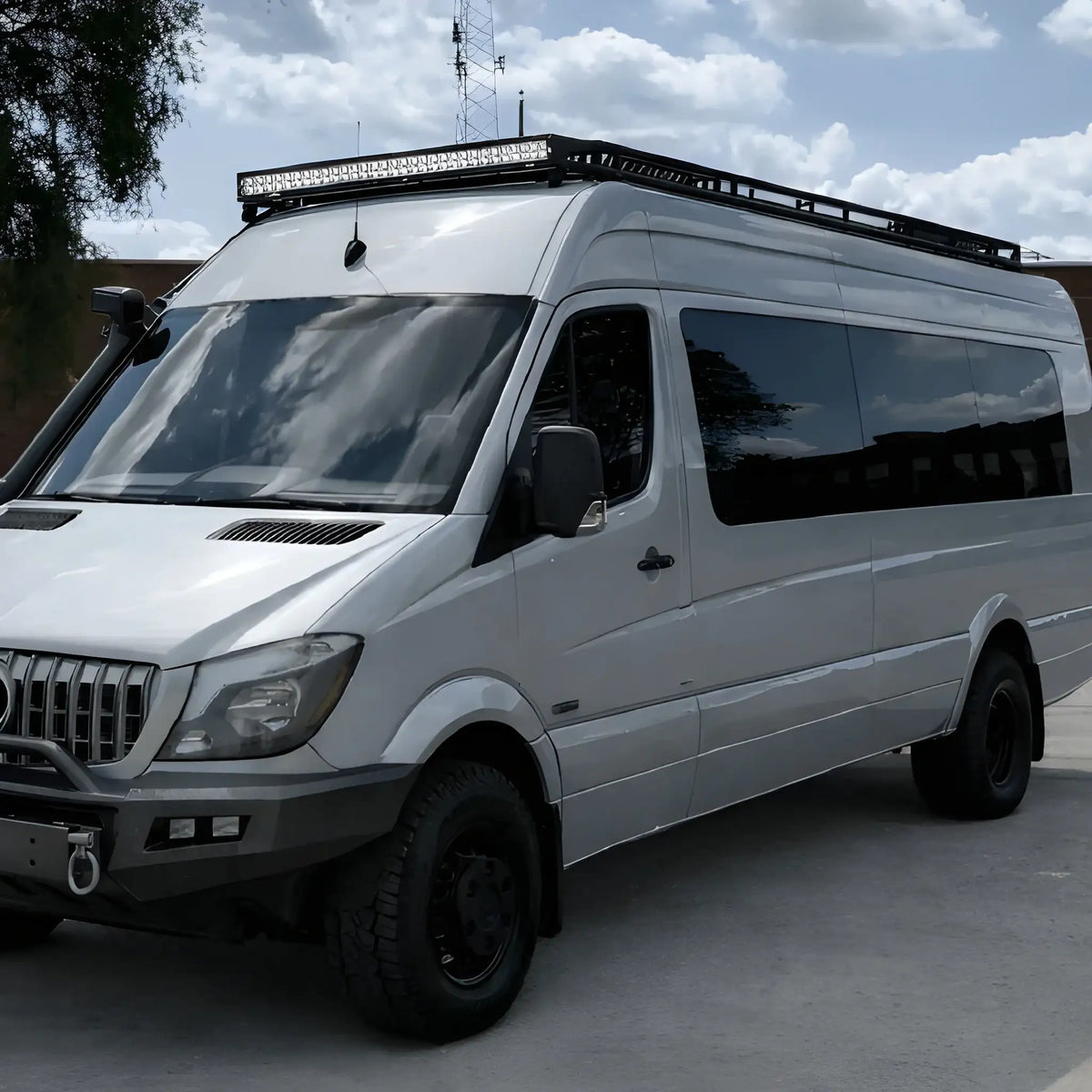 Front three-quarter view of a Mercedes Sprinter showing tinted driver-side windows, including the mid-panel solid window.