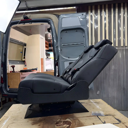 Side view of the NovaLux Duo RS on a workshop bench with its backrest reclined above the swivel mounting base.