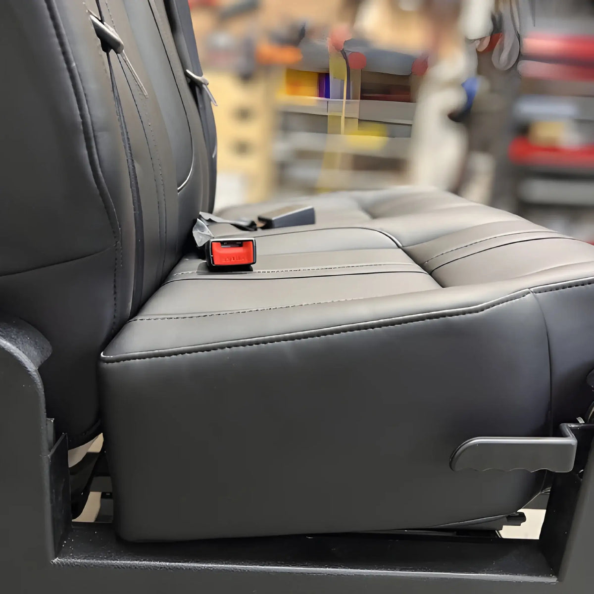 Side detail of the NovaLux Classic double swivel van seat showing the cushion, adjustment lever and mounting base.