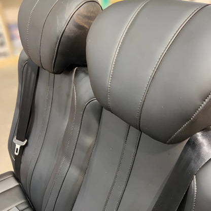 Close-up of the NovaLux Classic double van seat headrests, stitched backrests and integrated shoulder belts.