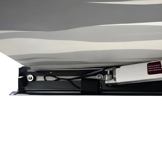 Close-up beneath the Vantrix electric awning showing the folding support arm, wiring and cassette under the patterned canopy.
